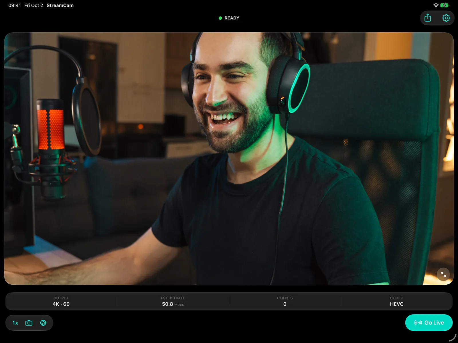StreamCam on iPad in landscape: a large preview of a streamer at their desk, the readout and controls along the bottom